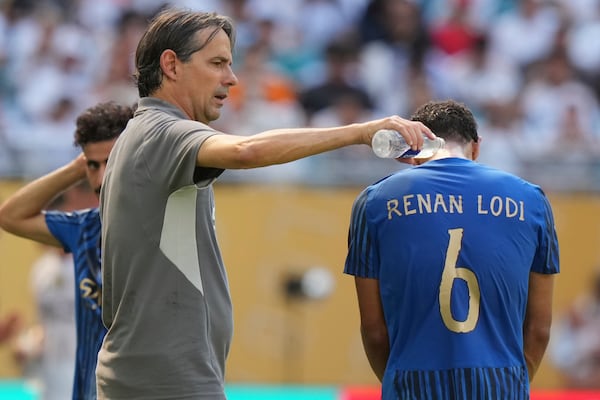 FILE - Al-Hilal manager Simone Inzaghi, left, uses water to cool down his player Renan Lodi during the Club World Cup group H soccer match between Real Madrid and Al Hilal in Miami, Fla., Wednesday, June 18, 2025. (AP Photo/Lynne Sladky, File)