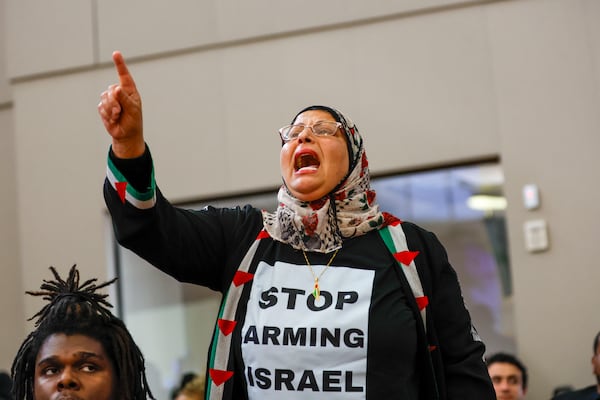 A protester chants, interrupting U.S. Sen. Raphael Warnock, D-Ga., during a town hall meeting at Zion Hill Baptist Church on Sunday, May 4, 2025. (Miguel Martinez/AJC)