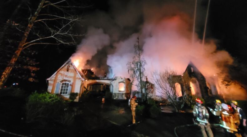 Gwinnett County firefighters worked through Sunday's early morning hours to put out a massive fire that gutted a 9,000-square-foot home in a gated subdivision near Suwanee.