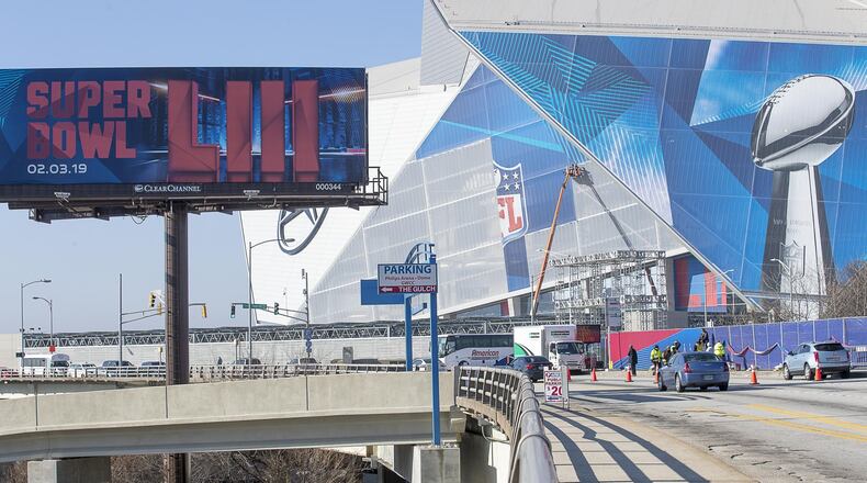 Workers  wrap parts of Mercedes-Benz Stadium with Super Bowl LIII graphics.