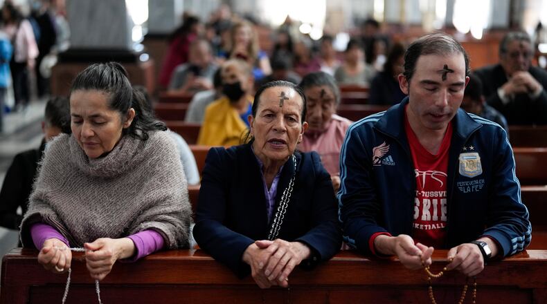 FILE - Catholics pray the rosary while a priest marks people's foreheads with ashes during Ash Wednesday Mass at the Church of the Divine Child in Bogota, Colombia, Wednesday, Feb. 14, 2024. (AP Photo/Fernando Vergara, File)