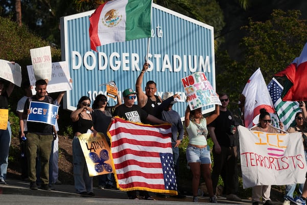 FILE - Demonstrators stage outside Dodger Stadium, June 21, 2025, in Los Angeles. (AP Photo/Damian Dovarganes, file)