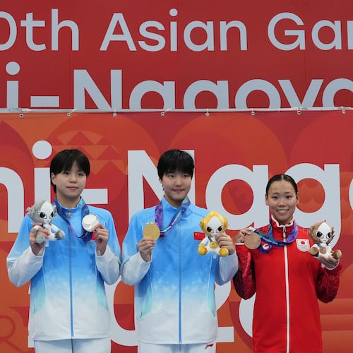 Gold medalist Yu Zidi of China, center, flanked by silver medalist Chang Mohan of China, left, and bronze medalist Misa Okuzono of Japan pose on the podium after the women's 200-meter butterfly final in swimming at the Asian Games in Tokyo, Japan, Sunday, Sept. 20, 2026. (AP Photo/Hiro Komae)