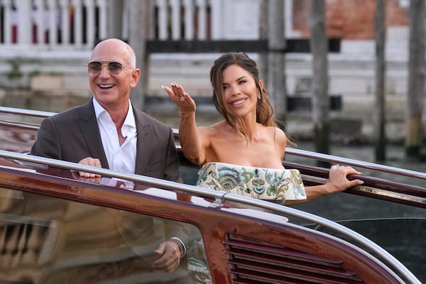 Jeff Bezos, left, and Lauren Sanchez kiss as they leave a hotel for their pre wedding reception, in Venice, Italy, Thursday, June 26, 2025. (AP Photo/Luca Bruno)
