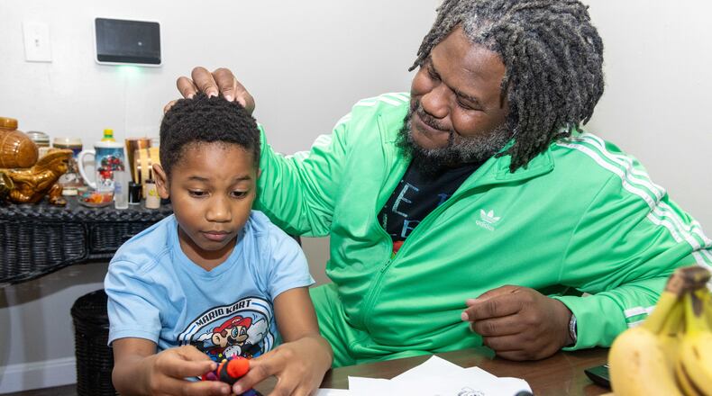 Michael Glenn (right) plays with his son MJ at his Decatur home. Glenn, a U.S. Air Force veteran, was facing homelessness after a job loss and a divorce until he was helped with housing assistance from The Home Depot Foundation LOVE Fund. PHIL SKINNER FOR THE ATLANTA JOURNAL-CONSTITUTION