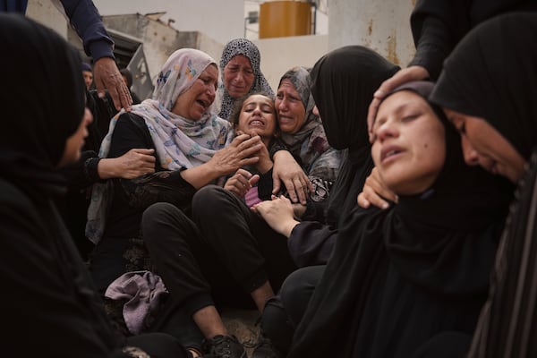 Lian Al-Za'anin, center, is comforted by relatives as she mourns the loss of her father, Rami Al-Za'anin, who was killed while heading to an aid distribution hub, at the morgue of the Shifa Hospital in Gaza City, on Thursday, July 3, 2025. (AP Photo/Jehad Alshrafi)
