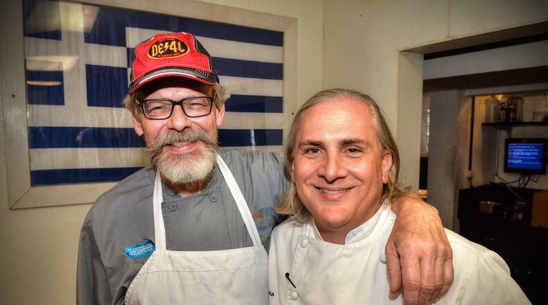 After sharing a few old kitchen war stories, Chef Tenney Flynn (left) poses on July 26, 2019, with old friend and former co-worker Pano I. Karatassos in the kitchen of Kyma in Buckhead where Karatassos is executive chef. CHRIS HUNT PHOTOGRAPHY