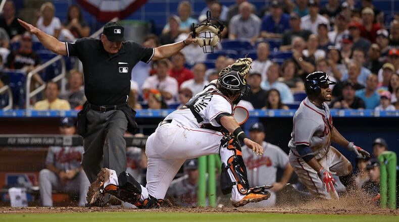 Eric Young Jr. #4 of the Atlanta Braves slides past Jarrod Saltalamacchia #39 of the Miami Marlins to score the go ahead run during Opening Day at Marlins Park on April 6, 2015 in Miami, Florida. (Photo by Mike Ehrmann/Getty Images)