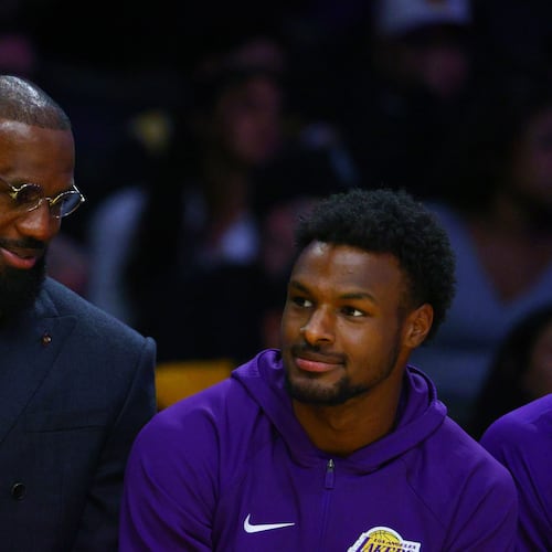 Los Angeles Lakers forward Lebron James, left, talks to guard Bronny James during the first half of an NBA basketball game against the Golden State Warriors, Tuesday, Oct. 21, 2025, in Los Angeles. (AP Photo/Ethan Swope)