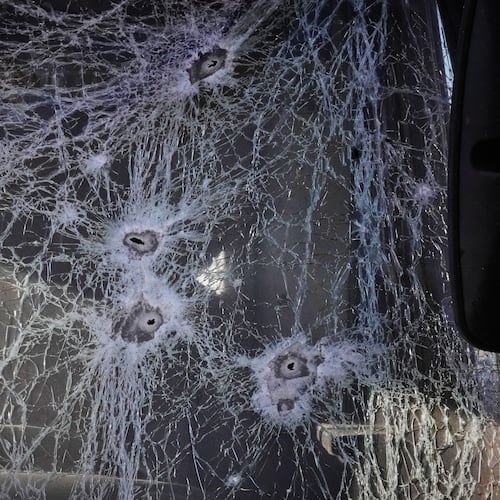 Shrapnel holes cover the glass of a damaged bus near railway workshops, following a Russia missile and drone attack, in Brovary close to Kyiv, Ukraine, Saturday, March 14, 2026. (AP Photo/Efrem Lukatsky)