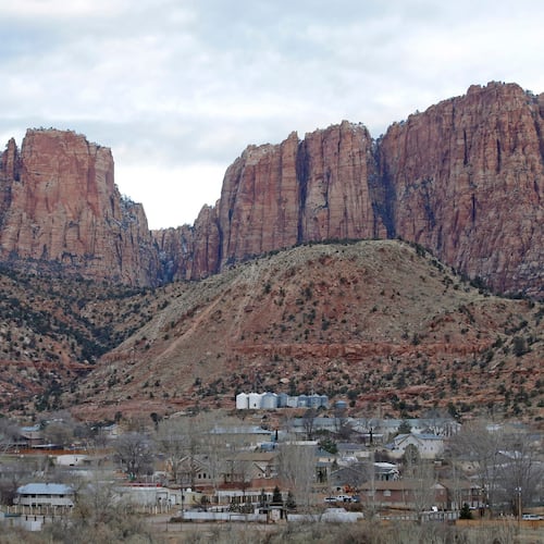 FILE - This photo shows Hildale, Utah, sitting at the base of Red Rock Cliff mountains, with its sister city, Colorado City, Ariz., in the foreground, Dec. 16, 2014. (AP Photo/Rick Bowmer, File)