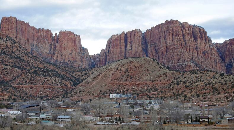 FILE - This photo shows Hildale, Utah, sitting at the base of Red Rock Cliff mountains, with its sister city, Colorado City, Ariz., in the foreground, Dec. 16, 2014. (AP Photo/Rick Bowmer, File)