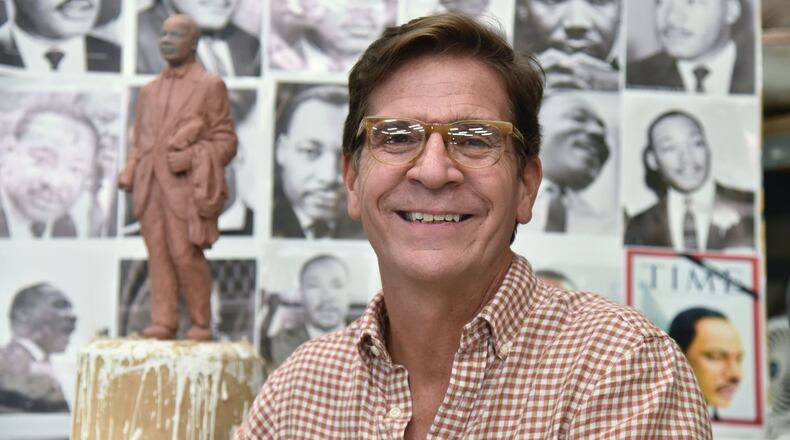 Sculptor Martin Dawe in front of a maquette, or model, and a wall of pictures he used to create the likeness of Martin Luther King Jr. in his studio. The statue will be unveiled on the grounds of the state Capitol Monday. HYOSUB SHIN / HSHIN@AJC.COM