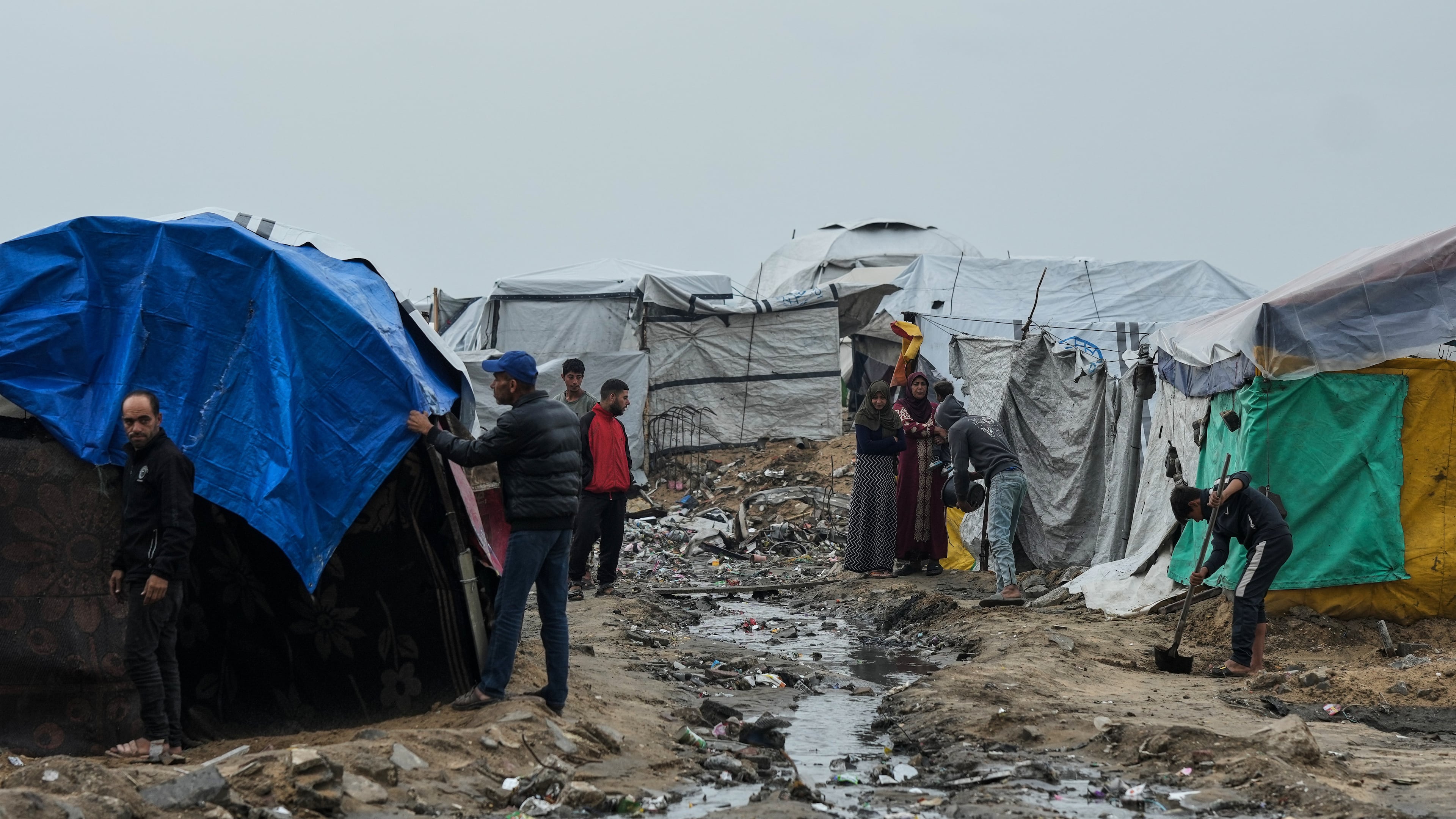 Displaced Palestinians repair their tents at a tent camp on the beach after a stormy weather in Gaza City, Wednesday, Dec. 10, 2025. (AP Photo/Jehad Alshrafi)