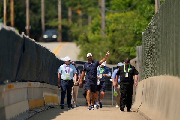 Dustin Johnson uses a pedestrian bridge over the Pennsylvania Turnpike, which divides Oakmont Country Club, during a practice round ahead of the U.S. Open golf tournament Wednesday, June 11, 2025, in Oakmont, Pa. (AP Photo/Carolyn Kaster)