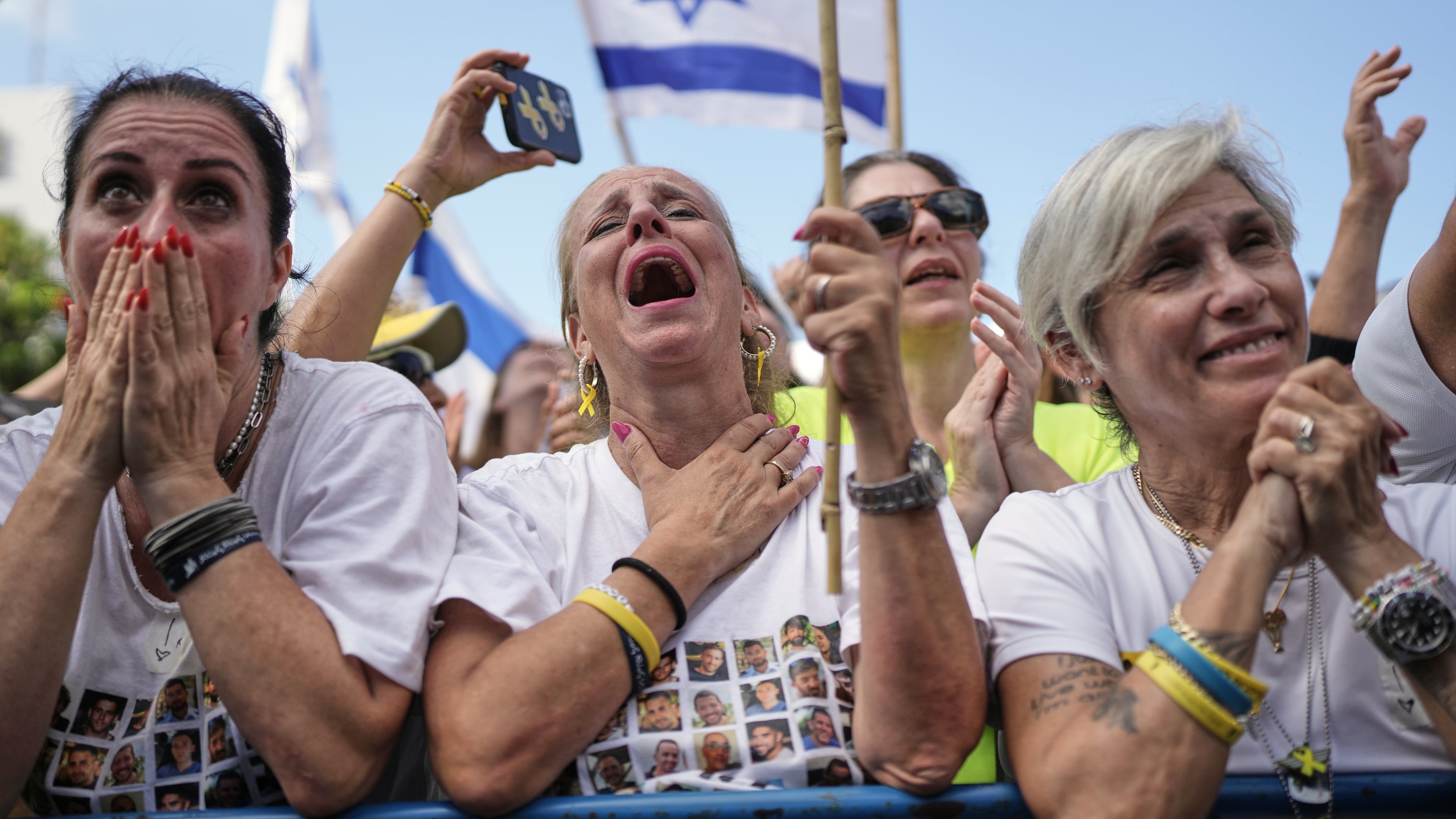 People react as they gather to watch a live broadcast of Israeli hostages released from Gaza at a plaza known as hostages square in Tel Aviv, Israel, Monday, Oct. 13, 2025. (AP Photo/Oded Balilty)