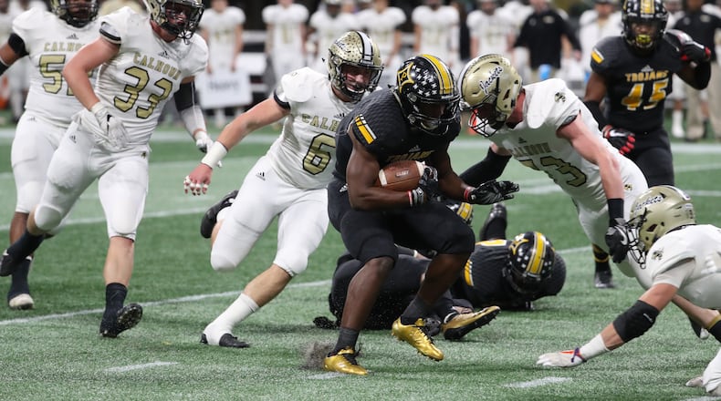 Peach County running back Trevon Woolfolk (9) is stopped by a host of Calhoun defenders in the first half of the Class AAA Championship at Mercedes-Benz Stadium Friday, December 8, 2017, in Atlanta. PHOTO / JASON GETZ