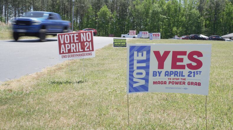 A truck passes political signs outside a polling place at Good Shepherd Catholic Church in South Hill, Va., on Tuesday, April 21, 2026. (AP Photo/Allen G. Breed)