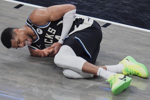 Milwaukee Bucks forward Giannis Antetokounmpo reacts after hitting his hand on the rim of the basket during the second half in Game 5 of an NBA basketball first-round playoff series against the Indiana Pacers, in Indianapolis, Tuesday, April 29, 2025. (AP Photo/Michael Conroy)