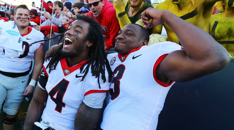 Georgia running back James Cook (left) and tailback Zamir White celebrate a 45-0 victory over Georgia Tech in a NCAA college football game on Saturday, Nov. 27, 2021, in Atlanta.   “Curtis Compton / Curtis.Compton@ajc.com”`