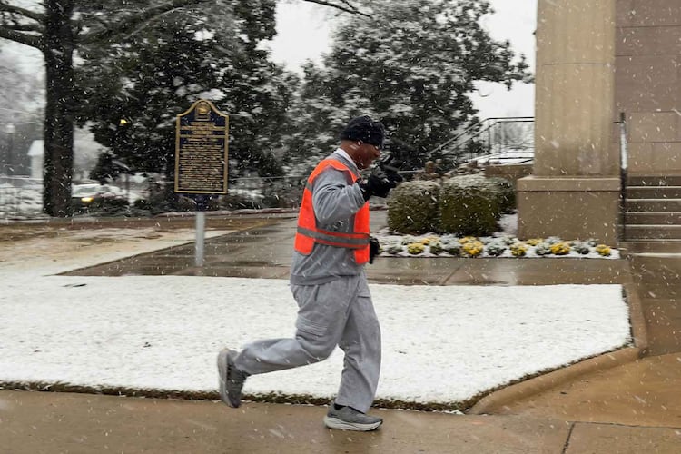 A Macon-Bibb County firefighter jogs down Vineville Avenue in the snow on the morning of Sunday, Jan. 18, 2026, near Vineville United Methodist Church, just west of I-75. (Joe Kovac Jr./AJC)
