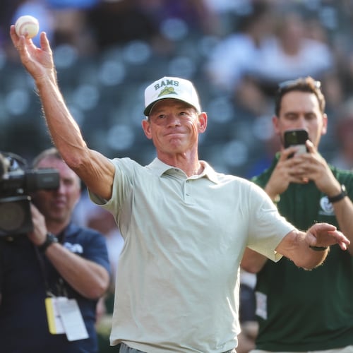 Colorado State University football head coach Jim Mora warms up before throwing the ceremonial first pitch before the Colorado Rockies host the Kansas City Royals in the first inning of a baseball game Saturday, Aug. 1, 2026, in Denver. (AP Photo/David Zalubowski)