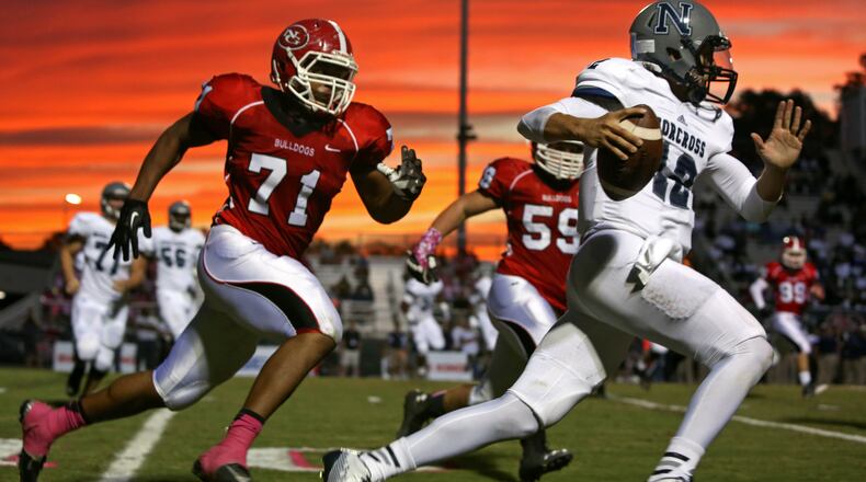 October 3, 2014 - Suwanee, Ga: The sun sets as Norcross quarterback Jacob Gassert (12) scrambles for yards against North Gwinnett defensive lineman Anree Saint-Amour (71) in the first half of their game Friday in Suwanee, Ga., October 3, 2014. JASON GETZ / SPECIAL Georgia Tech commit Anree Saint-Amour, a defensive end at North Gwinnett High, selected Tech over Stanford, Michigan State and Kentucky, among others. His selection, among others, bodes well for the Yellow Jackets’ signing class. Beautiful picture, isn’t it? (AJC file photo by Jason Getz)