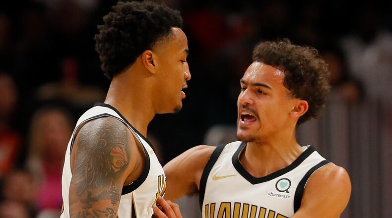 John Collins reacts with Trae Young after dunking against Marcin Gortat  of the LA Clippers at State Farm Arena on Nov. 19, 2018 in Atlanta, Georgia.