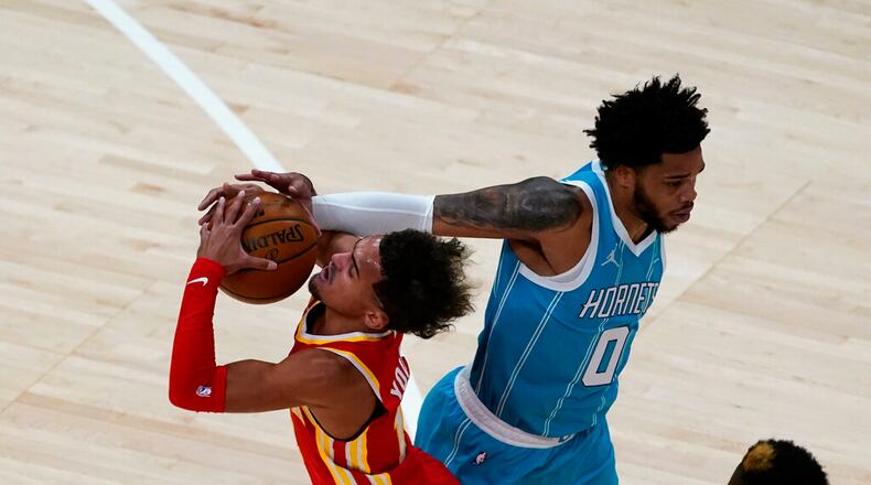 Hawks guard Trae Young, left, tries to drive past Charlotte Hornets forward Miles Bridges (0) during the first half of an NBA basketball game Wednesday, Jan. 6, 2021, in Atlanta. (AP Photo/John Bazemore)