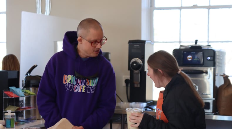Peter Clark (left) and Ashley McCormick serve coffee drinks and pastries at Brightside Cafe in Buford. Brightside Cafe gives adults with disabilities a place to find success, said co-owner Jennifer Elinburg. (Courtesy of Brightside Cafe)