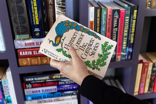 Karin Slaughter holds a copy of a Flannery O’Connor book at her home near Blue Ridge on Friday, July 11, 2025. (Arvin Temkar/AJC)