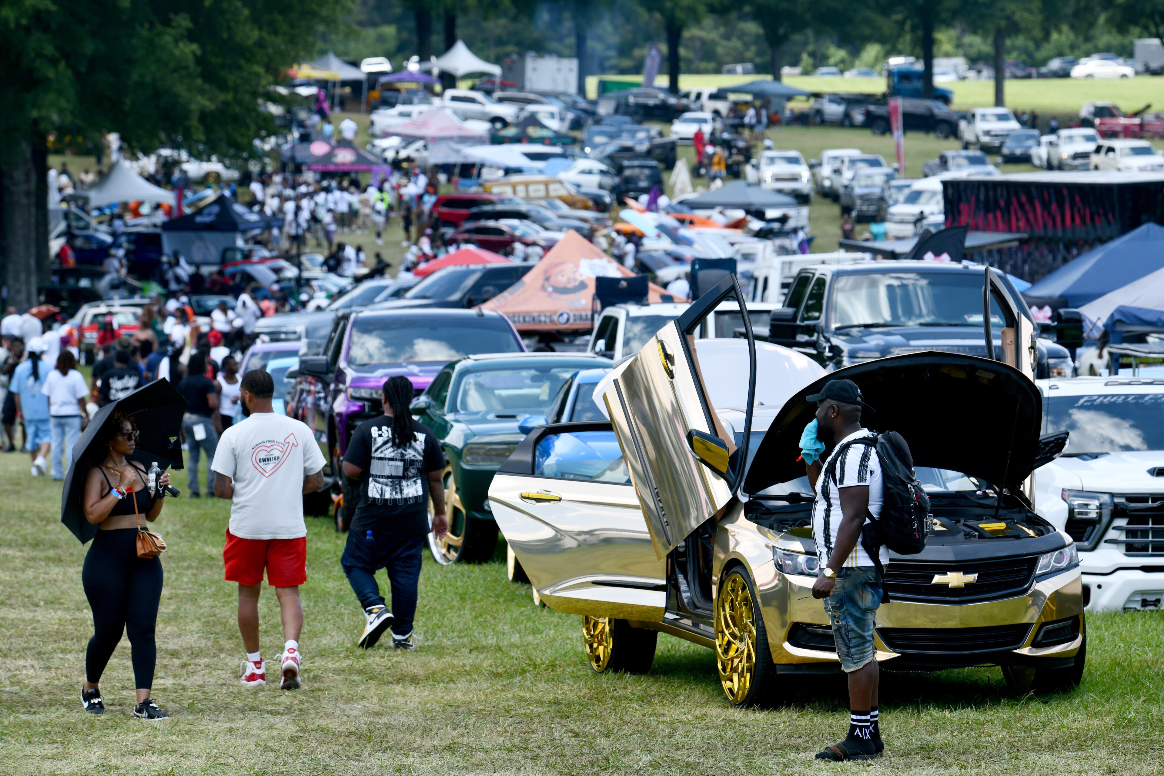 Attendees walk through some of classic/custom and luxury vehicles on Rick Ross’s property during the 4th Annual Rick Ross Car and Bike Show, Saturday, June 7, 2025, in Fayetteville. The 4th Annual Rick Ross Car and Bike Show will include a vendor market with more than 30 vendors, food trucks, fleets of classic/custom automobiles, luxury vehicles, boats, RVs and trailers on the front of the mansion. Stage performances include Plies, Ross' new signee Nino Breeze and Ross himself. (Hyosub Shin / AJC)
