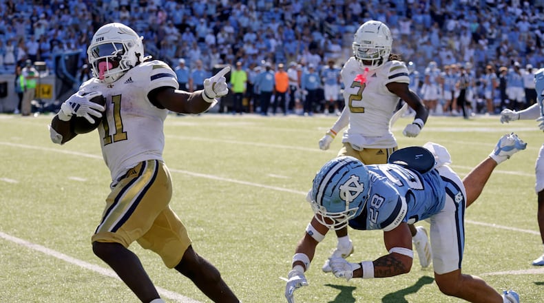 Georgia Tech running back Jamal Haynes (11) outruns North Carolina defensive back Alijah Huzzie (28) to score the winning touchdown on a long run in the closing seconds of an NCAA college football game Saturday, Oct. 12, 2024, in Chapel Hill, N.C. (AP Photo/Chris Seward)