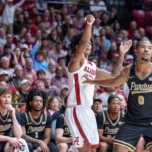 Alabama guard Aden Holloway, left, shoots and hits a 3-point basket over Purdue guard C.J. Cox (0) during the first half of an NCAA college basketball game, Thursday, Nov. 13, 2025, in Tuscaloosa, Ala. (AP Photo/Vasha Hunt)