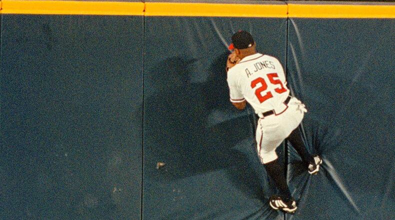 Andruw Jones climbs the wall at Turner Field to make a catch against the Houston Astros on Aug. 9, 1999, in Atlanta.