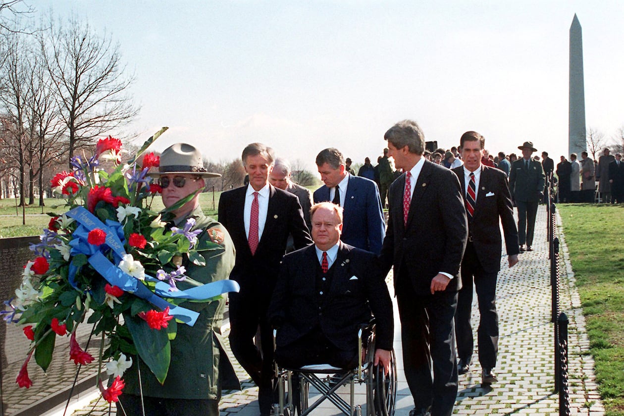 In this photo from 1997, then-U.S. Sen. Max Cleland, D-Ga. (in wheelchair), and fellow senators (left to right) Bob Kerrey, D-Neb.; John McCain, R-Ariz.; Charles Hagel, R-Neb.; John Kerry, D-Mass.; and Chuck Robb, D-Va. walk along the Vietnam Veterans Memorial wall behind the wreath they would lay to commemorate the 15th anniversary of groundbreaking for the memorial. All six senators served in Vietnam, and Cleland lost both legs and an arm in that war. (Rick McKay/Washington Bureau)