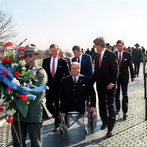 In this photo from 1997, then-U.S. Sen. Max Cleland, D-Ga. (in wheelchair), and fellow senators (left to right) Bob Kerrey, D-Neb.; John McCain, R-Ariz.; Charles Hagel, R-Neb.; John Kerry, D-Mass.; and Chuck Robb, D-Va. walk along the Vietnam Veterans Memorial wall behind the wreath they would lay to commemorate the 15th anniversary of groundbreaking for the memorial. All six senators served in Vietnam, and Cleland lost both legs and an arm in that war. (Rick McKay/Washington Bureau)