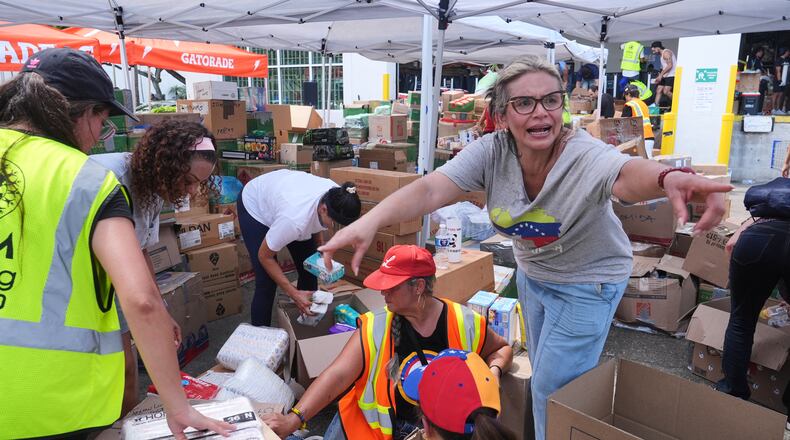 Lisa Galindez calls on other volunteers to help pack baby items at the Global Empowerment Mission Venezuela relief donation site Tuesday, June 30, 2026, in Doral, Fla. (AP Photo/Marta Lavandier)