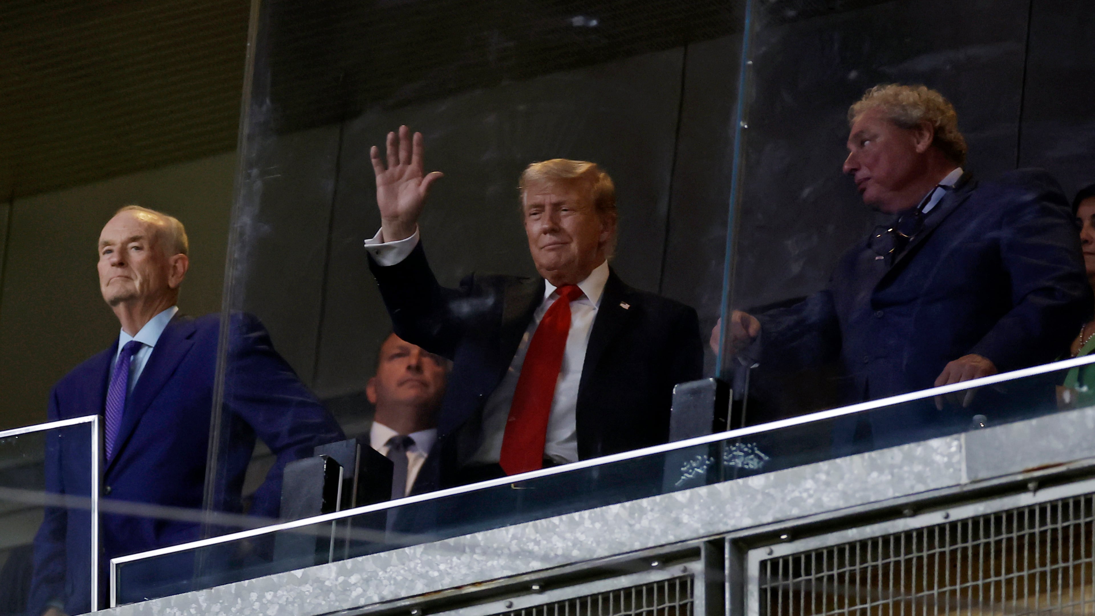 President Donald Trump, center, gestures next to New York Yankees president Randy Levine, front right, during the seventh inning of a baseball game against the Detroit Tigers, Thursday, Sept. 11, 2025, in New York. (AP Photo/Adam Hunger)