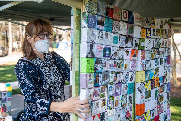 02/17/2021 —Decatur, Georgia — North Decatur Presbyterian Church member Ellen Gadberry hangs origami boxes featuring faces of people killed by gun violence in Georgia on the church property in Decatur, Wednesday, February 17, 2021. (Alyssa Pointer / Alyssa.Pointer@ajc.com)