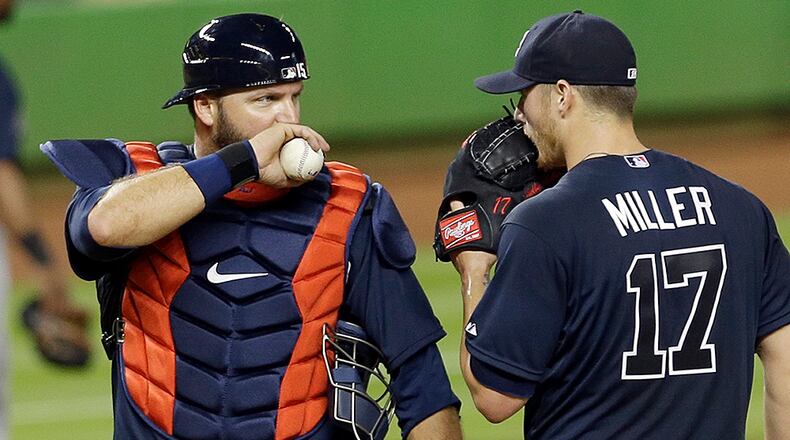 Atlanta Braves catcher A.J. Pierzynski, left, talks to Shelby Miller (17) after Miller gave up an infield hit to Miami Marlins' Christian Yelich (21) in the third inning of a baseball game, Wednesday, April 8, 2015, in Miami. (AP Photo/Alan Diaz)