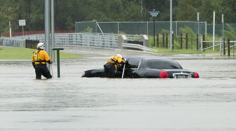 Rescuers search a flooded car on Park Row Drive adjacent to the Addicks Reservoir in west Houston after Hurricane Harvey on Tuesday August 29, 2017. JAY JANNER / AMERICAN-STATESMAN