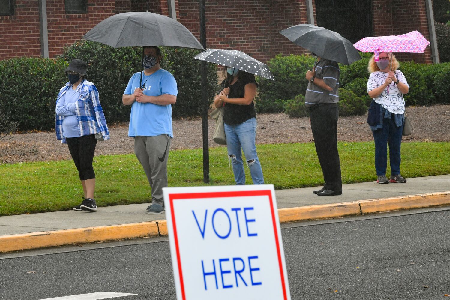 Voters brave the rain and a three hour wait line as the first day of early voting is shown underway on Monday, Oct. 12, 2020, at George Pierce Park in Suwanee, Ga. JOHN AMIS FOR THE ATLANTA JOURNAL- CONSTITUTION