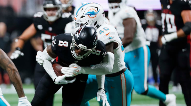 Atlanta Falcons tight end Kyle Pitts (8) gets tacke by Miami Dolphins linebacker Willie Gay Jr. (40) during the second half of an NFL football game at Mercedes-Benz Stadium in Atlanta on Sunday, October 26, 2025. (Miguel Martinez/AJC)