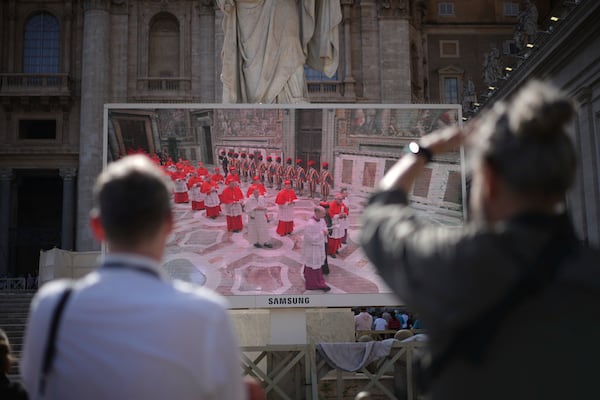 Faithful watch a giant screen showing images of cardinals entering the conclave, in St. Peter's Square at the Vatican, Wednesday, May 7, 2025. (AP Photo/Andrew Medichini)
