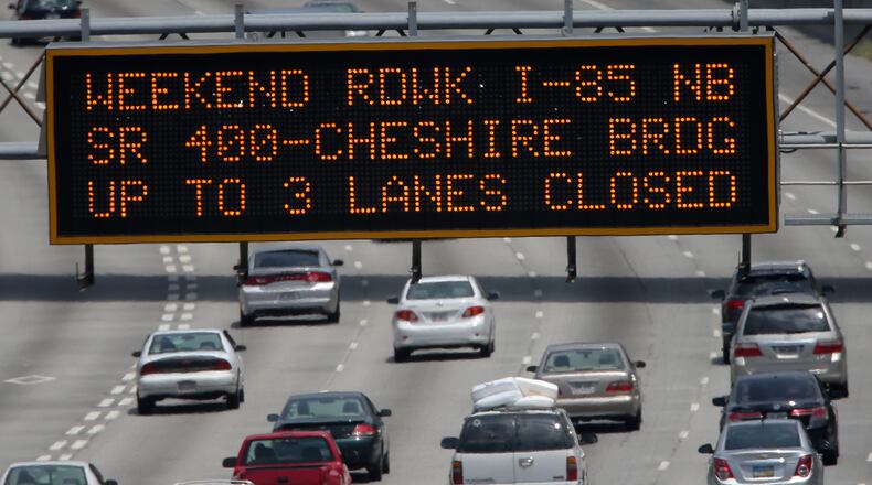 Cars make their way North on I-85 in Atlanta, under a sign warning of weekend construction Friday afternoon August 2, 2013. Several projects around the Metro will close lanes and cause delays throughout the weekend.