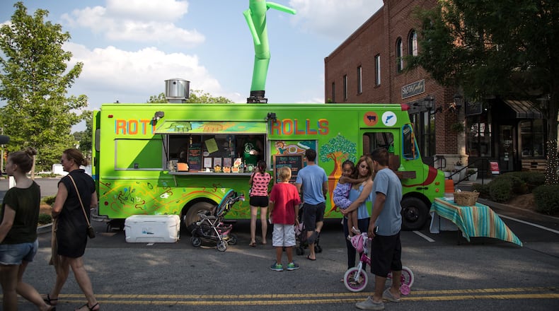 People gather around the Roti Rolls food truck during Food Truck Friday in Duluth on May 27, 2016. Food Truck Friday takes place every Friday from May through October from 6 to 9 p.m. STEVE SCHAEFER / SPECIAL TO THE AJC