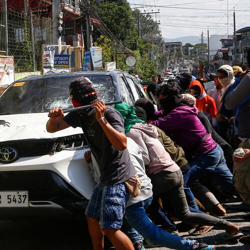 A group attacks a vehicle from an opposing group outside a school used as a polling center during the Bangsamoro Autonomous Region in Muslim Mindanao parliamentary elections in Cotabato city, southern Philippines, Monday, Sept. 14, 2026. (AP Photo)