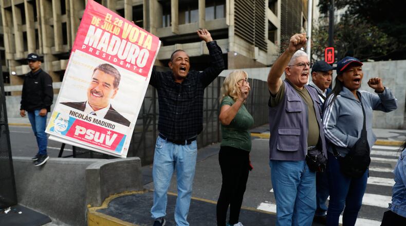 Supporters display a poster of Venezuelan President Nicolás Maduro in Caracas, Venezuela, Saturday, Jan. 3, 2026, after U.S. President Donald Trump announced Maduro had been captured and flown out of the country. (AP Photo/Cristian Hernandez)