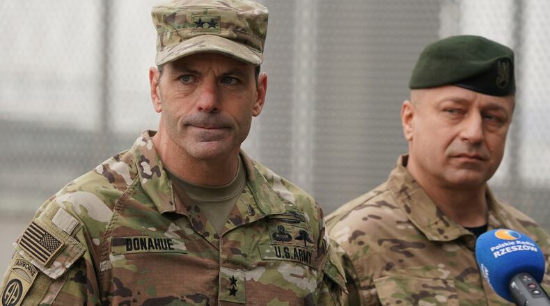 FILE - U.S. Army General Christopher Donahue, left, commanding general of the 82nd Airborne Division, and Polish General Wojciech Marchwica speak to journalists after unloading vehicles from a transport plane arriving from Fort Bragg at the Rzeszow-Jasionka airport in southeastern Poland, on Feb. 6, 2022. (AP Photo, File)